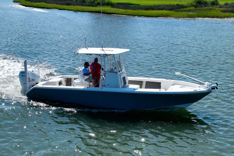 Slide: The Image of A blue and white boat cruising on calm water with two people on board. - 19