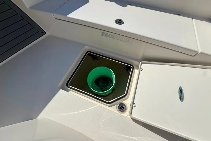 Slide: The Image of An open storage compartment on a boat with a green bucket inside. - 26