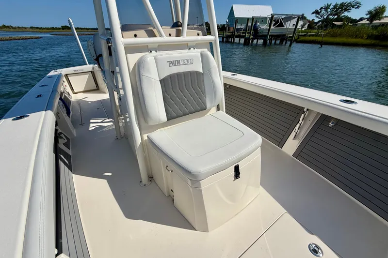 Slide: The Image of A 2022 Pathfinder 2700 Open boat on the water with a cushioned seat and helm station. - 27