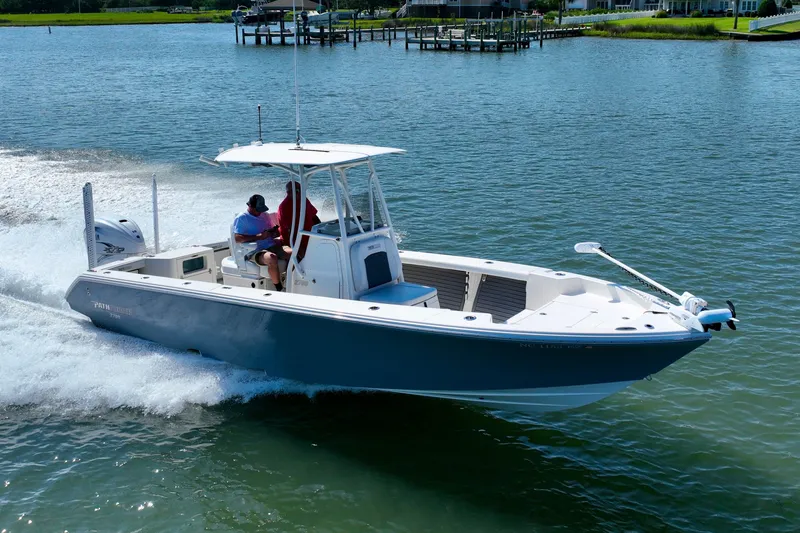 Slide: The Image of A 2022 Pathfinder 2700 Open boat cruising on calm waters with two people on board. - 18