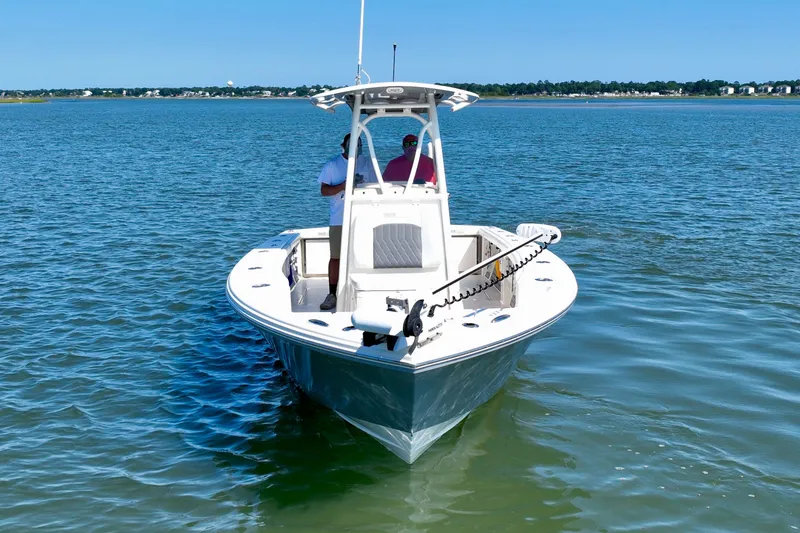 Slide: The Image of A white boat on calm water with two people on board and a clear blue sky. - 4