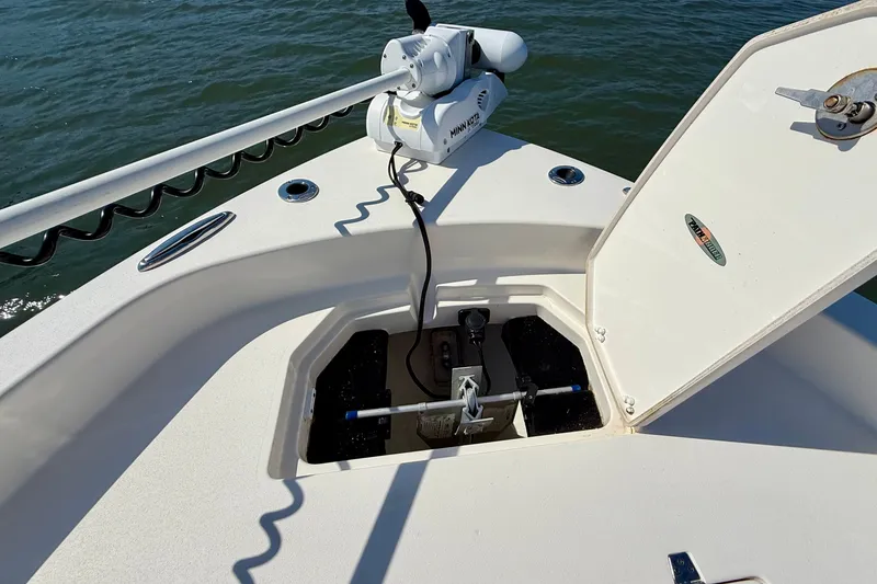 Slide: The Image of An open storage compartment on a boat with a trolling motor and water in the background. - 22