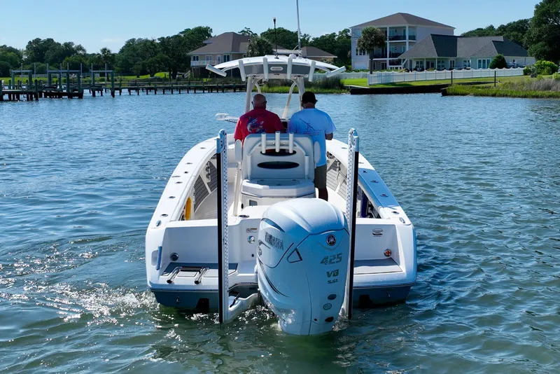 Slide: The Image of Two people ride a white Pathfinder 2700 Open boat on calm water. - 9