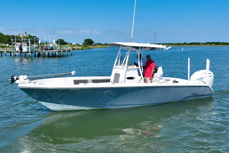 Slide: The Image of A white open-deck boat on calm water with two people on board. - 3