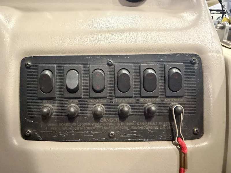 Slide: The Image of Control panel of a 1996 Chaparral 210 Sunesta with multiple switches and warning labels. - 25