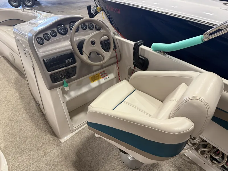Slide: The Image of The image shows the cockpit of a 1996 Chaparral 210 Sunesta with a helm and cushioned seat. - 21