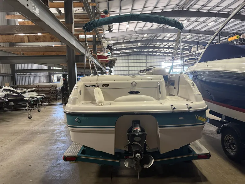 Slide: The Image of A 1996 Chaparral 210 Sunesta boat is in a warehouse. It features a turquoise stern. - 6