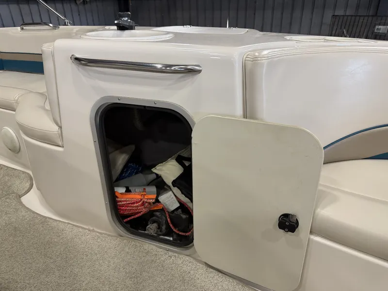Slide: The Image of An open storage compartment on a 1996 Chaparral 210 Sunesta boat reveals ropes and equipment. - 32