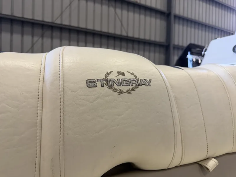 Slide: The Image of Close-up of a white seat with the Stingray logo in a boat warehouse. - 11