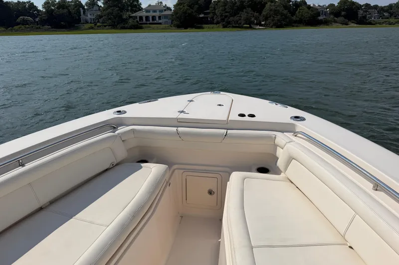 Slide: The Image of 2019 Grady-White Canyon 336 boat interior with cushioned seating on calm water. - 22