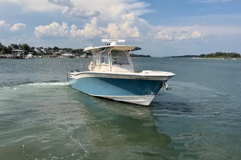 Slide: The Image of 2019 Grady-White Canyon 336 boat cruising on a calm lake under a partly cloudy sky. - 7