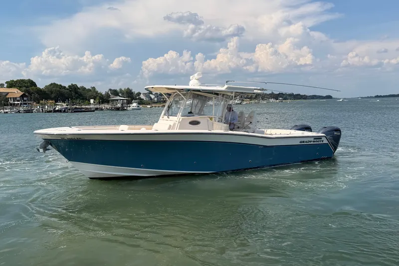 Slide: The Image of 2019 Grady-White Canyon 336 boat on calm water under a partly cloudy sky. - 2