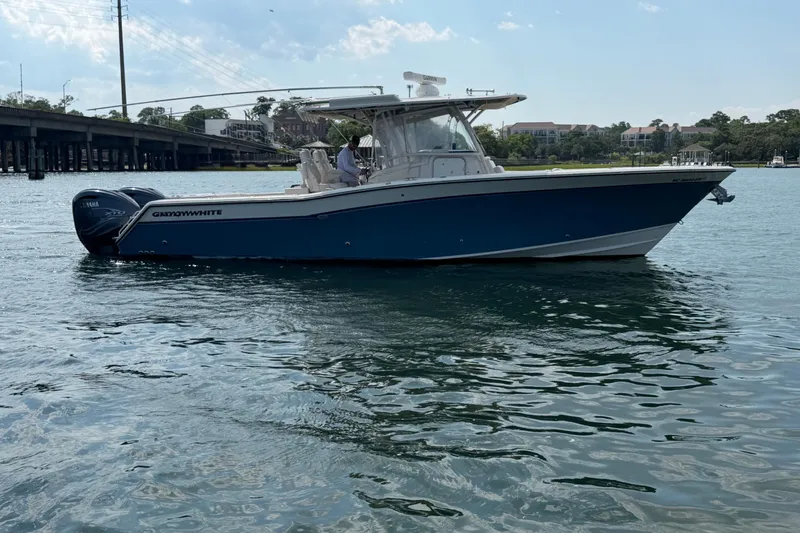 Slide: The Image of 2019 Grady-White Canyon 336 boat on water, featuring sleek design and twin engines. - 13