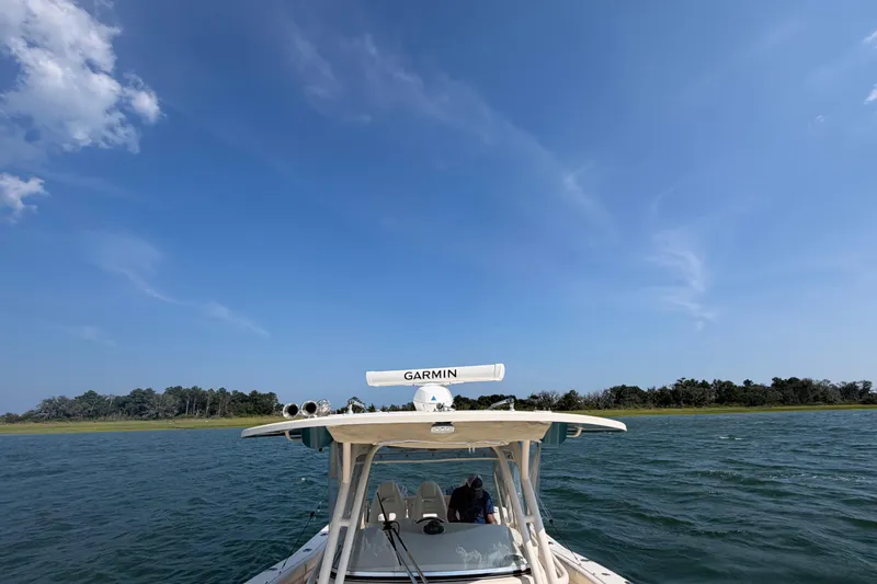 Slide: The Image of 2019 Grady-White Canyon 336 boat on water under clear blue sky. - 24