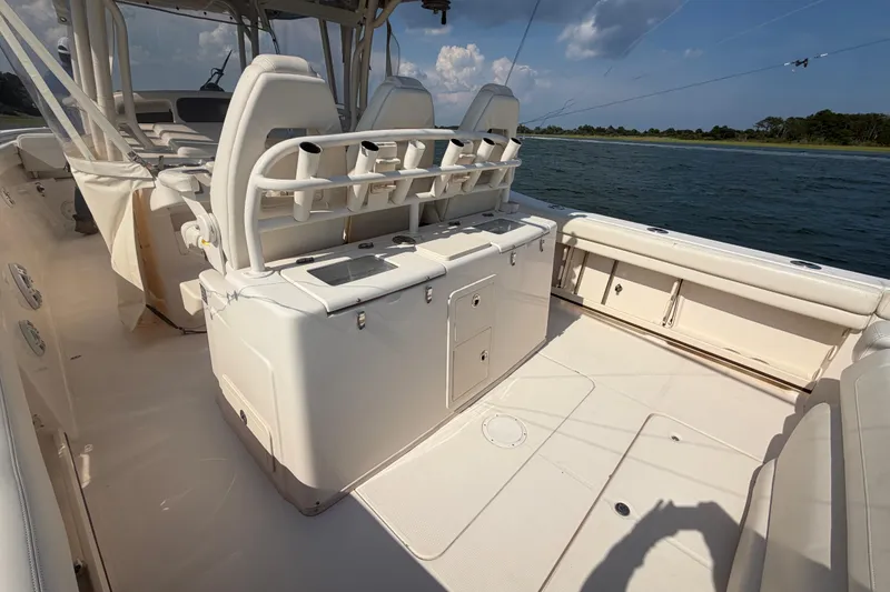Slide: The Image of 2019 Grady-White Canyon 336 boat interior with seating and storage, on calm water. - 49