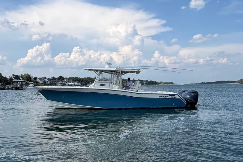 Slide: The Image of 2019 Grady-White Canyon 336 boat on calm water under a partly cloudy sky. - 9