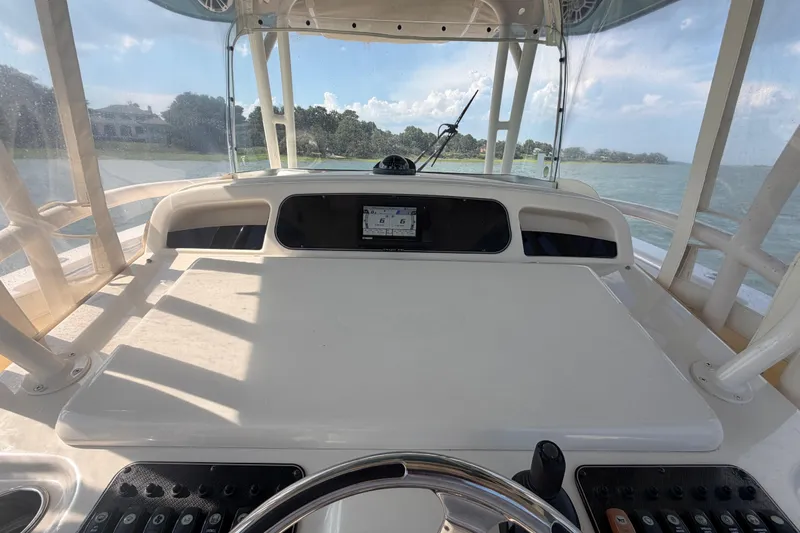 Slide: The Image of 2019 Grady-White Canyon 336 helm with steering wheel and control panel, overlooking water. - 40