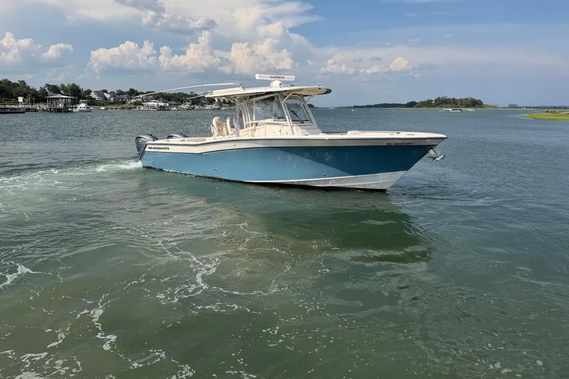 Slide: The Image of 2019 Grady-White Canyon 336 boat cruising on a calm, scenic waterway. - 8