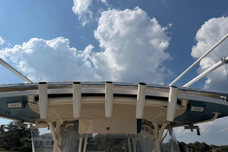 Slide: The Image of 2019 Grady-White Canyon 336 boat with rod holders against a cloudy sky backdrop. - 61
