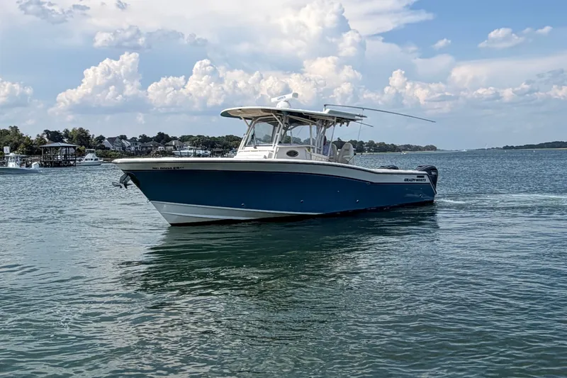 Slide: The Image of 2019 Grady-White Canyon 336 boat on calm water under a partly cloudy sky. - 12