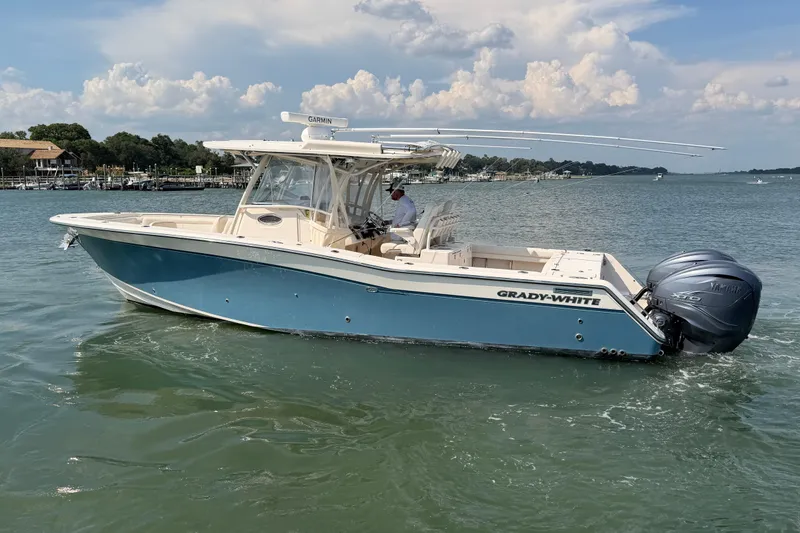 Slide: The Image of 2019 Grady-White Canyon 336 boat cruising on a calm lake under a cloudy sky. - 4