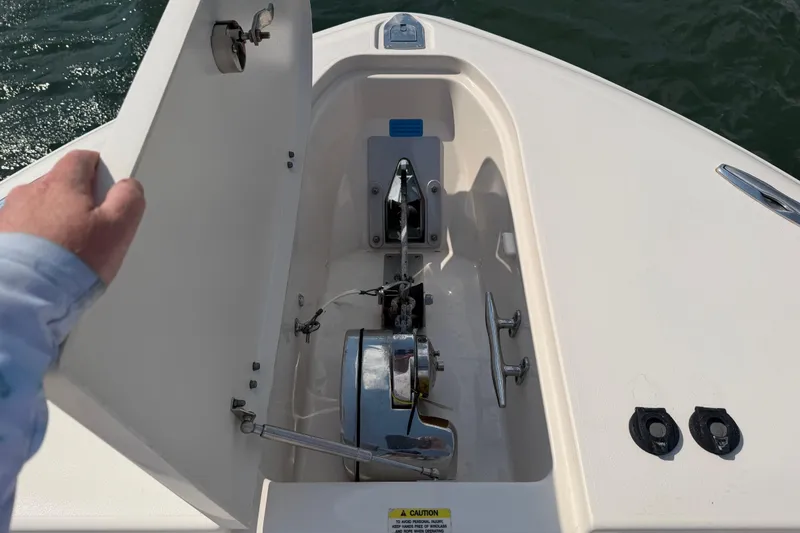 Slide: The Image of 2019 Grady-White Canyon 336 anchor locker with open hatch, showing anchor mechanism. - 19