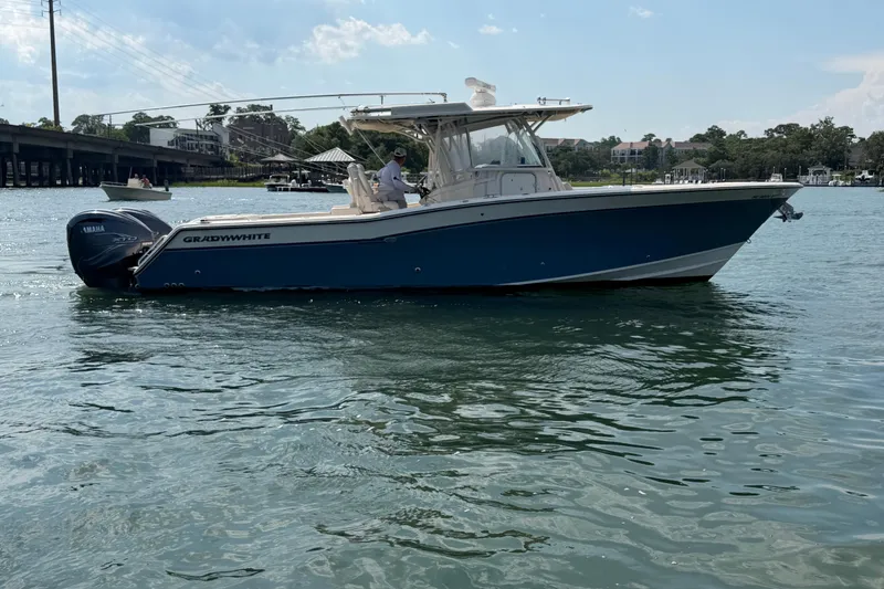 Slide: The Image of 2019 Grady-White Canyon 336 boat on water, featuring Yamaha engines, under a clear sky. - 14