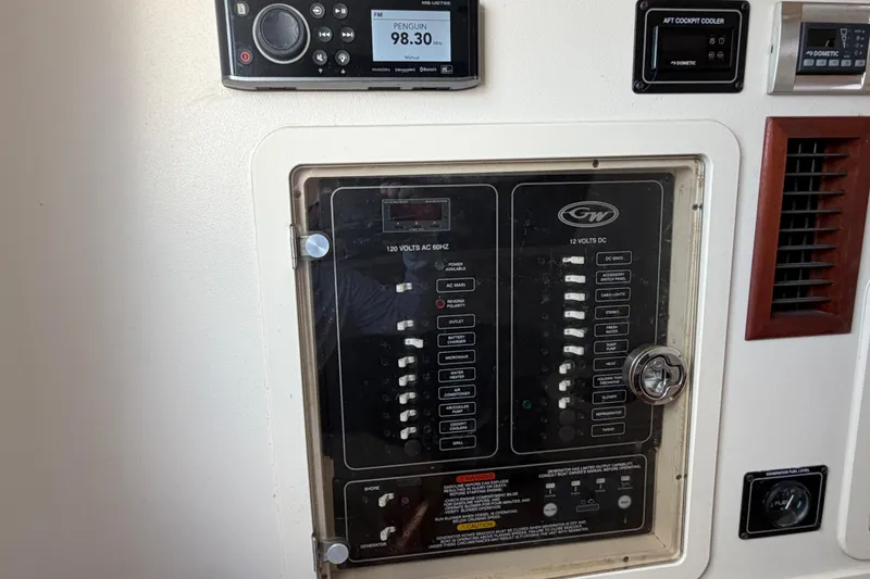 Slide: The Image of Control panel of a 2019 Grady-White Canyon 336 boat, featuring electrical switches and radio display. - 32
