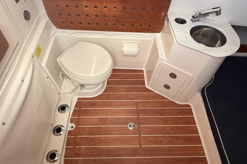 Slide: The Image of 2019 Grady-White Canyon 336 boat bathroom with wooden flooring, toilet, and sink. - 34