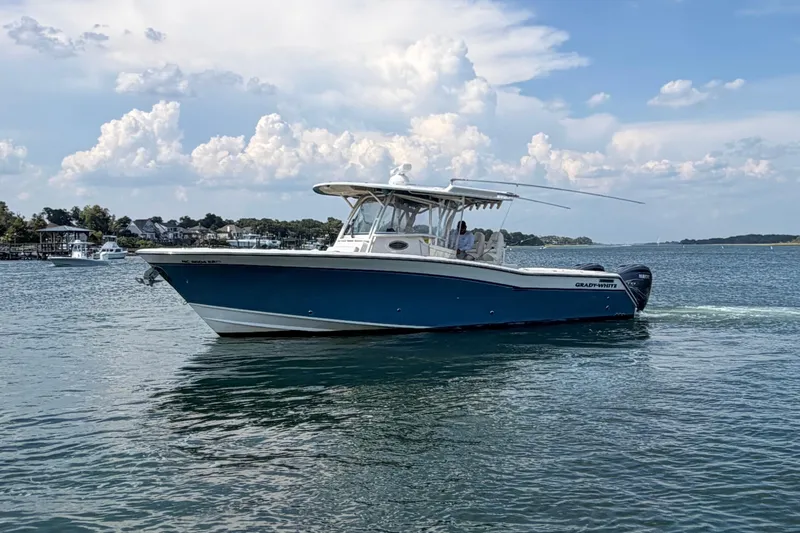 Slide: The Image of 2019 Grady-White Canyon 336 boat cruising on a calm lake under a cloudy sky. - 11