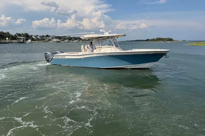 Slide: The Image of 2019 Grady-White Canyon 336 boat cruising on a calm lake under a clear sky. - 6