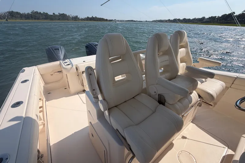 Slide: The Image of 2019 Grady-White Canyon 336 boat interior with luxurious seating and dual engines on water. - 44