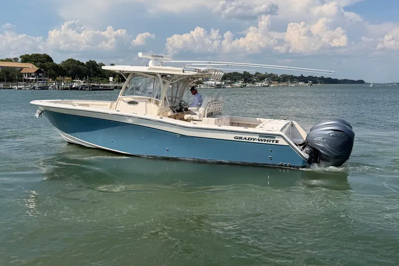 Slide: The Image of 2019 Grady-White Canyon 336 boat cruising on calm waters under a cloudy sky. - 3