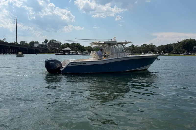 Slide: The Image of 2019 Grady-White Canyon 336 boat cruising on a sunny day near a bridge. - 17