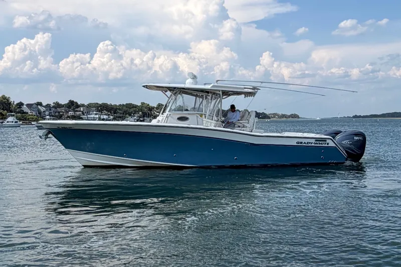 Slide: The Image of 2019 Grady-White Canyon 336 boat on calm water under a partly cloudy sky. - 10