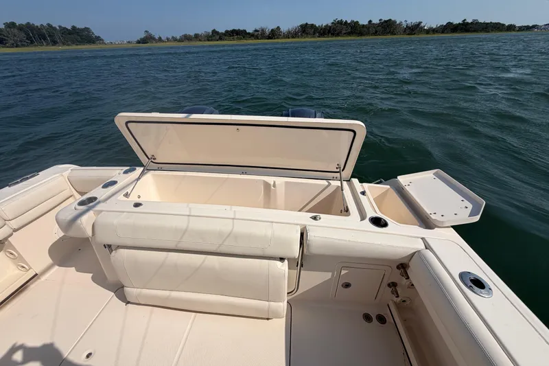 Slide: The Image of 2019 Grady-White Canyon 336 boat with open storage compartment on calm water. - 65