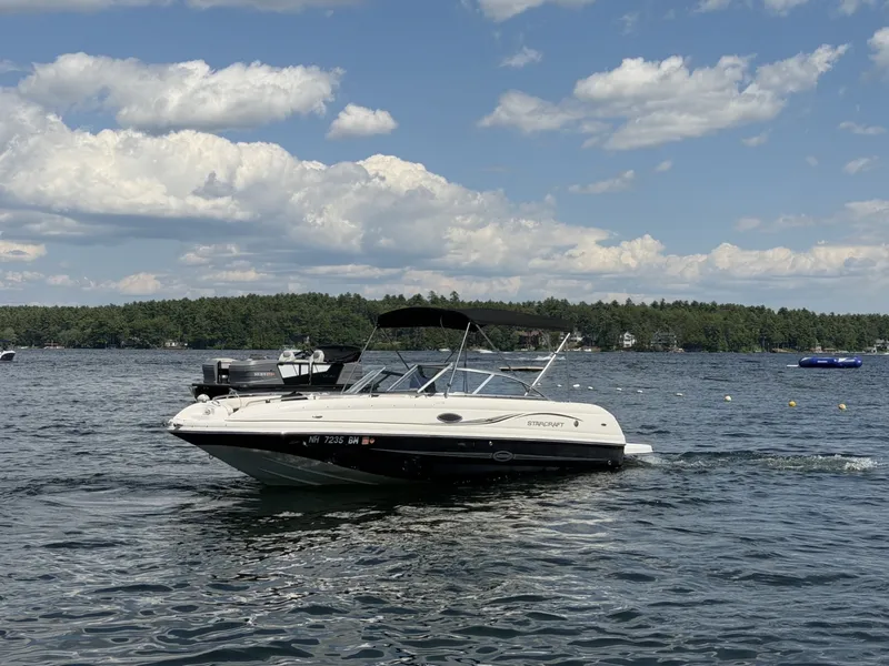 Slide: The Image of A 2011 Starcraft 2210 boat cruising on a calm lake under a partly cloudy sky. - 4
