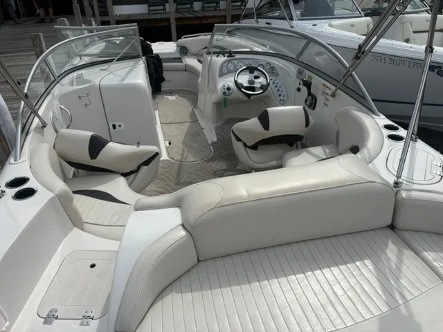 Slide: The Image of The image shows the cockpit of a 2011 Starcraft 2210 boat with white upholstery and a helm. - 13