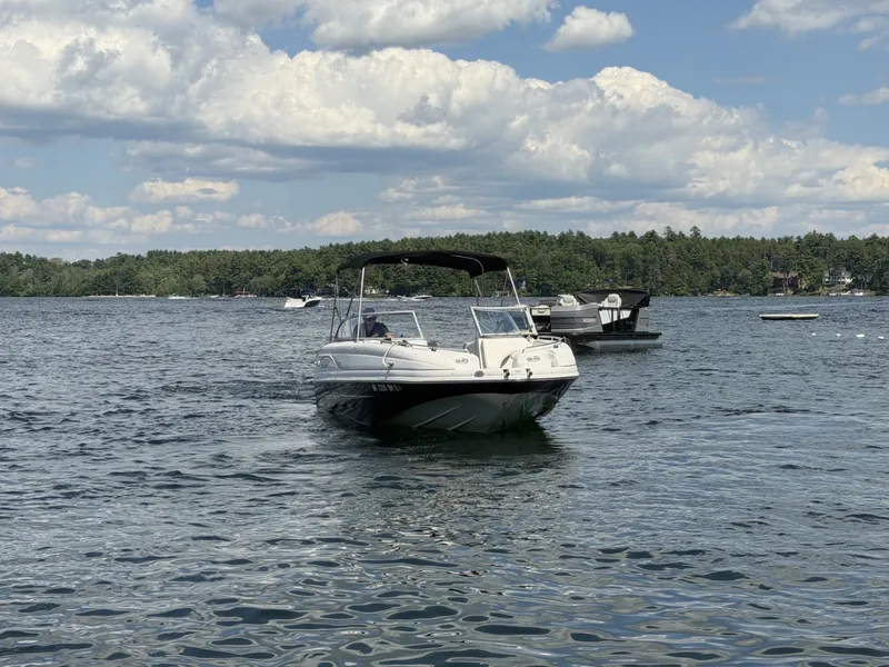 Slide: The Image of A 2011 Starcraft 2210 boat on a calm lake with a wooded shoreline in the background. - 5