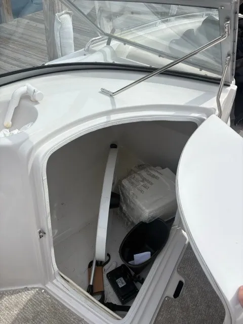 Slide: The Image of An open storage compartment on a 2011 Starcraft 2210 boat, containing various items. - 15