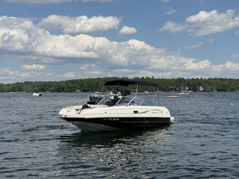 Slide: The Image of A 2011 Starcraft 2210 boat floats on a calm lake under a partly cloudy sky. - 6