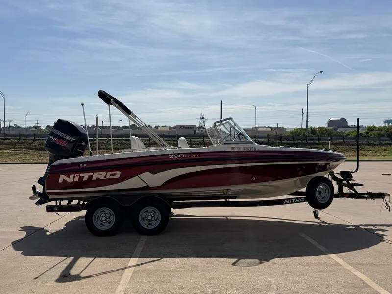 Slide: The Image of A 2013 Nitro 290 Sport boat on a trailer in a parking lot. - 5