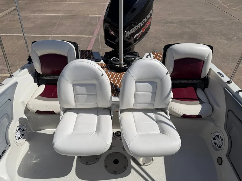 Slide: The Image of Interior view of a Nitro 290 Sport boat with four seats and a Mercury engine. - 12