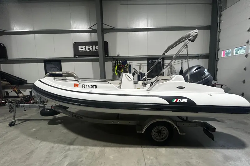 Slide: The Image of 2022 AB Inflatables Nautilus 17 DLX boat on trailer in garage setting. - 2