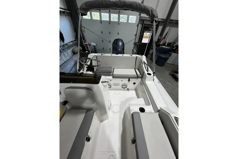 Slide: The Image of 2022 AB Inflatables Nautilus 17 DLX boat interior with seating and steering wheel in a garage. - 4