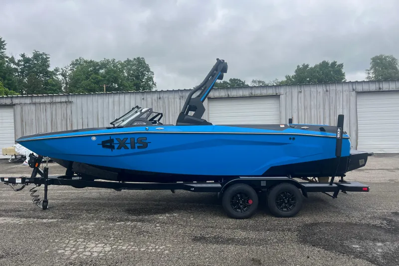 The Image of 2026 Axis A225 boat in vibrant blue on a trailer, parked outdoors. - 0