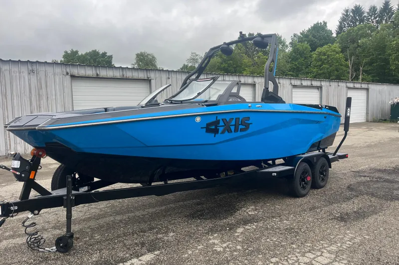 Slide: The Image of 2026 Axis A225 blue boat on trailer, parked near storage units. - 6