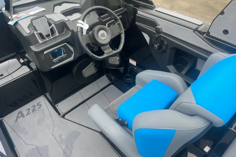 Slide: The Image of Interior of 2026 Axis A225 boat featuring modern steering and blue-gray seating. - 2