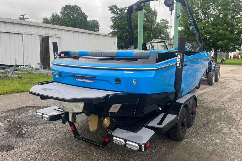 Slide: The Image of 2026 Axis A225 boat in vibrant blue on a trailer, parked outdoors. - 8