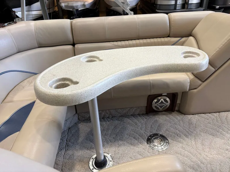 Slide: The Image of Interior of a boat with beige upholstered seating and a small table with cup holders. - 2